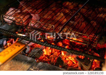 Sizzling Meat on the Grill Over Charcoal, Perfect for a Delicious Outdoor Barbecue Gathering 128185130