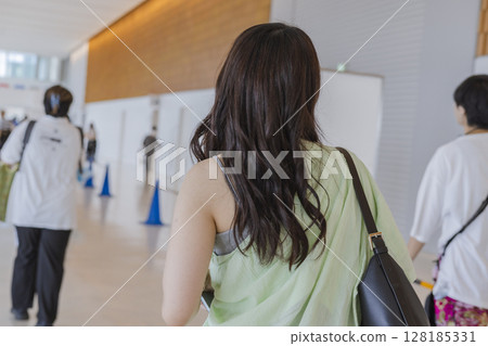 Woman in summer clothes with loosely permed hair, view from behind, no face, back Woman in summer clothes with loosely permed hair, view from behind, no face, back 128185331