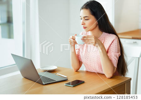 Woman working with laptop computer at home Woman working with laptop computer at home 128185453