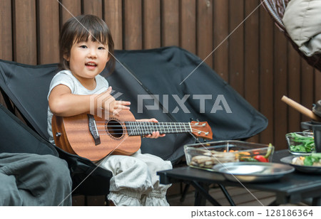 Girl, daughter, child playing guitar and enjoying camping, glamping, vacation home, private lodging Girl, daughter, child playing guitar and enjoying camping, glamping, vacation home, private lodging 128186364