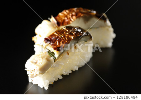 黑色背景下拍攝的烤鯖魚壽司 黑色背景下拍攝的烤鯖魚壽司 128186484