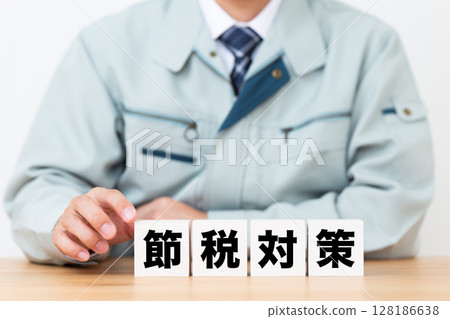 Tax saving block and middle-aged male businessman wearing work clothes Tax saving block and middle-aged male businessman wearing work clothes 128186638