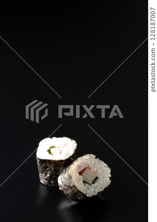 Nori rolls with plum, shiso and yam photographed against a black background 128187007