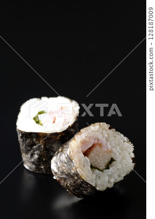 Nori rolls with plum, shiso and yam photographed against a black background Nori rolls with plum, shiso and yam photographed against a black background 128187009