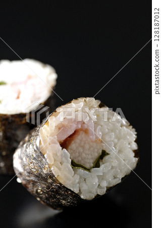 在黑色背景下拍攝的海苔卷,內含梅子、紫蘇和山藥 在黑色背景下拍攝的海苔卷,內含梅子、紫蘇和山藥 128187012