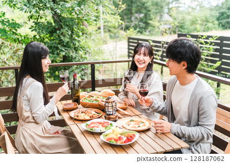 Group of young Asian men and women having a home party glamping on a wooden deck 128187062