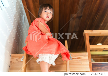 Girl playing in the loft/attic of a cottage 128187318