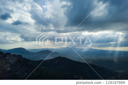 A Scenic Mountain Valley with Dramatic Clouds and Sunbeams A Scenic Mountain Valley with Dramatic Clouds and Sunbeams 128187989