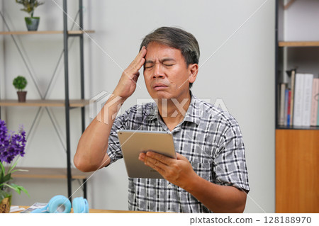 Asian senior man is having a headache. 128188970