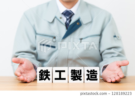 鐵廠製造塊和穿工作服的中年男性商人 鐵廠製造塊和穿工作服的中年男性商人 128189223