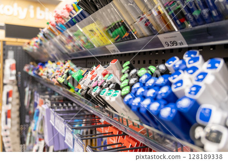 Extensive selection of vibrant colorful pens and markers displayed neatly on retail store shelves, offering diverse writing tools for school and office needs 128189338