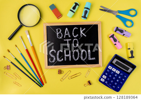 Vibrant school supplies and a BACK TO SCHOOL chalkboard message flat lay, symbolizing educational readiness and the excitement of a new academic year Vibrant school supplies and a BACK TO SCHOOL chalkboard message flat lay, symbolizing educational readiness and the excitement of a new academic year 128189364