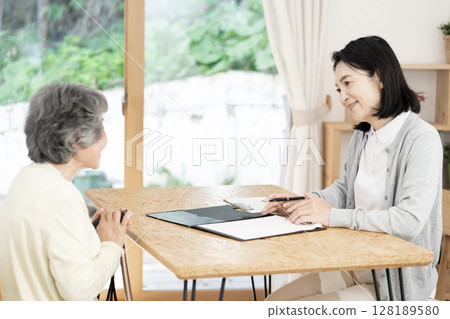 Care manager/care manager conducting a home visit Care manager/care manager conducting a home visit 128189580