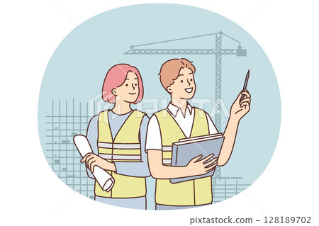 Man and woman in construction uniforms inspect construction site with unfinished high-rise buildings 128189702