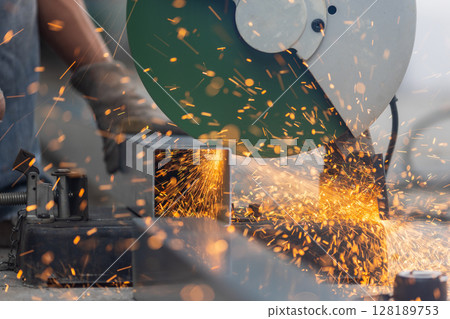 Worker cutting steel pipe in construction site. 128189753