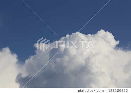 White cloud illuminated by sunlight against blue sky 128189822