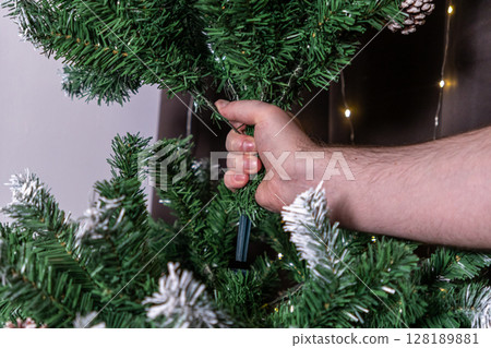 assembling artificial christmas tree by connecting branches for festive home decor assembling artificial christmas tree by connecting branches for festive home decor 128189881