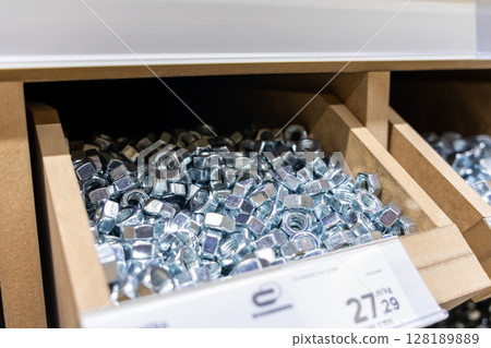 metal nuts in a wooden storage box at a hardware store, close-up view of fastening materials for construction and repair metal nuts in a wooden storage box at a hardware store, close-up view of fastening materials for construction and repair 128189889