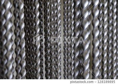 close-up of twisted metal rods with intricate patterns in industrial setting close-up of twisted metal rods with intricate patterns in industrial setting 128189895