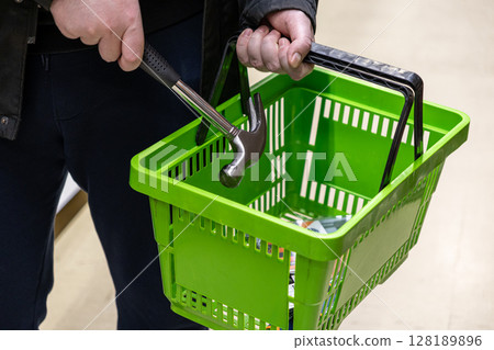 shopping basket with a hammer and tools for home improvement in a hardware store aisle shopping basket with a hammer and tools for home improvement in a hardware store aisle 128189896