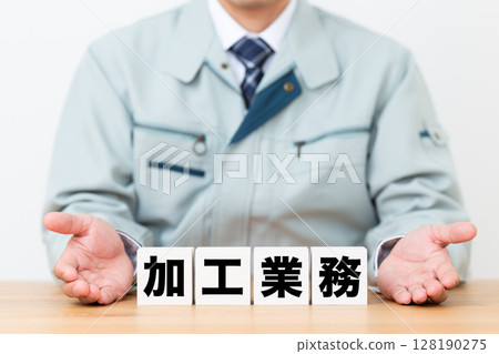 A middle-aged male businessman wearing work clothes and a block of processing work 128190275