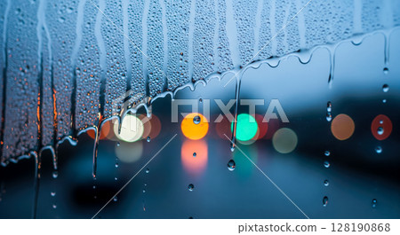 Rainy car window with dripping water drops and colorful bokeh, beautiful night drive concept with blurry city street traffic lights Rainy car window with dripping water drops and colorful bokeh, beautiful night drive concept with blurry city street traffic lights 128190868