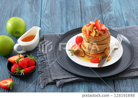 pancakes topped with apple slices and strawberries pancakes topped with apple slices and strawberries 128191698