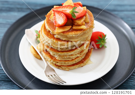 pancakes topped with apple slices and strawberries pancakes topped with apple slices and strawberries 128191701