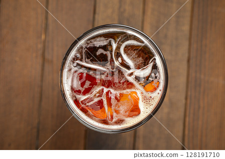Glass of kvass with ice cubes on wooden table 128191710