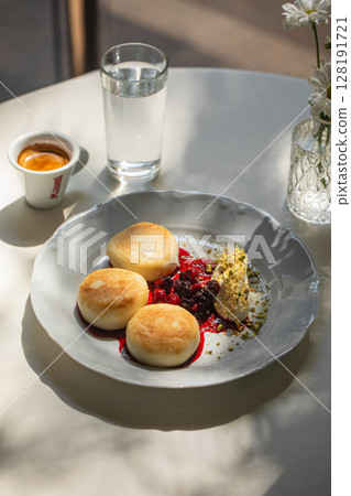 Portion of curd pancakes syrniki with berry jam 128191721