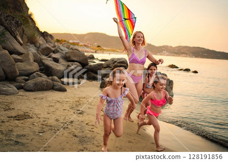 Joyful moments of a family flying kites and splashing at the beach 128191856