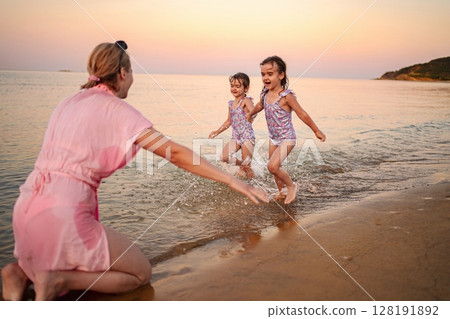 Joyful moments at the beach with family under a sunset sky Joyful moments at the beach with family under a sunset sky 128191892