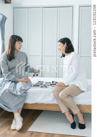 Mother and daughter looking at ultrasound images, eagerly awaiting the birth of their baby 128192206