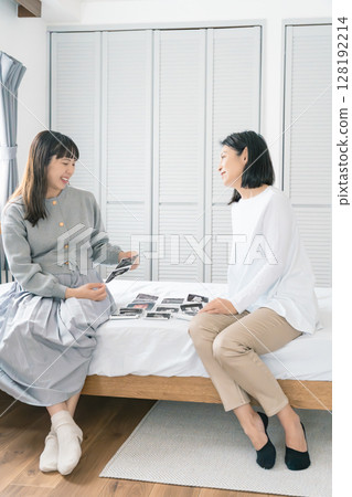 Mother and daughter looking at ultrasound images, eagerly awaiting the birth of their baby Mother and daughter looking at ultrasound images, eagerly awaiting the birth of their baby 128192214