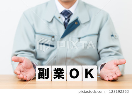一位身穿工作服的中年男性商人,手裡拿著一個方塊,表示可以做副業 一位身穿工作服的中年男性商人,手裡拿著一個方塊,表示可以做副業 128192263