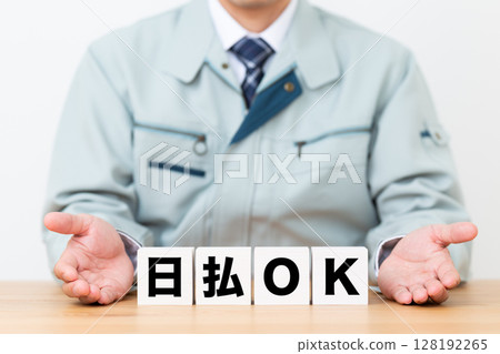 寫著「日結OK」的方塊和一位身穿工作服的中年男性商人 128192265