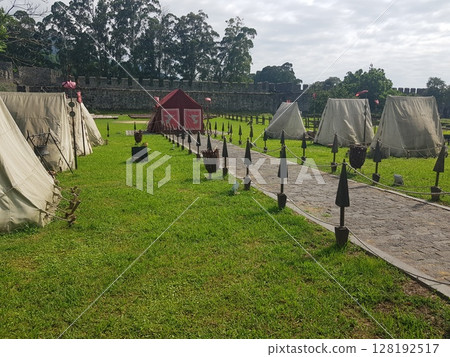 Ancient Roman Encampment on Green Grass at a Historical Reenactment in Roman Fortress. Ancient Roman Encampment on Green Grass at a Historical Reenactment in Roman Fortress. 128192517