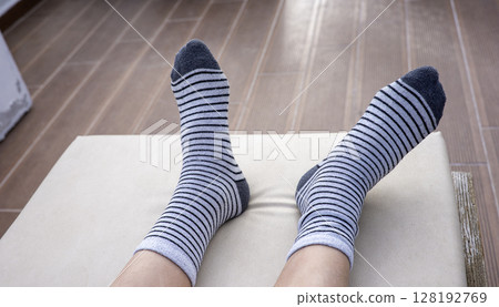 Gray socks with black stripes on boys feet 128192769