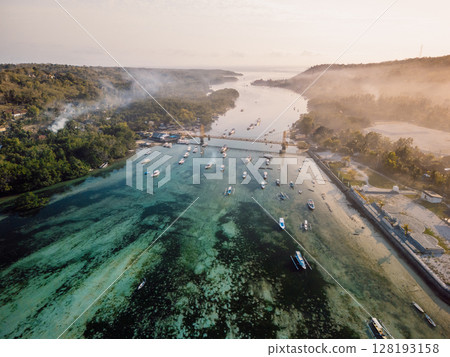 Aerial view of a bridge connecting two tropical islands over a narrow ocean channel. Nusa Lembongan and Nusa Ceningan bridge. Aerial view of a bridge connecting two tropical islands over a narrow ocean channel. Nusa Lembongan and Nusa Ceningan bridge. 128193158