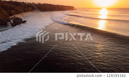 Surfers on Padang Padang surfspot at sunset with perfect swell waves Surfers on Padang Padang surfspot at sunset with perfect swell waves 128193162