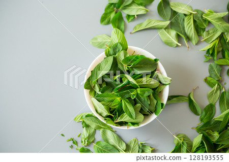 Top view of green mint in white bowl 128193555