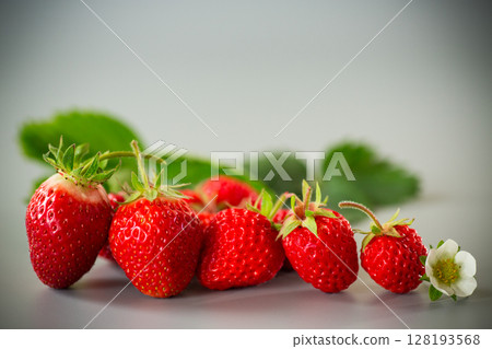 Ripe strawberries on a stylish gray surface Ripe strawberries on a stylish gray surface 128193568
