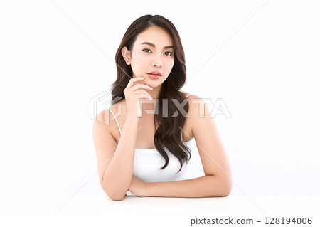 A beautiful young Asian woman with clean, fresh skin against a white background. Skincare, facial treatment, cosmetology, beauty, and spa. An elegant portrait of an Asian woman. 128194006