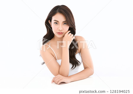 A beautiful young Asian woman with clean, fresh skin against a white background. Skincare, facial treatment, cosmetology, beauty, and spa. An elegant portrait of an Asian woman. A beautiful young Asian woman with clean, fresh skin against a white background. Skincare, facial treatment, cosmetology, beauty, and spa. An elegant portrait of an Asian woman. 128194025