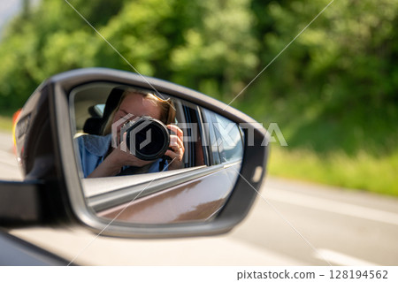 Photographer taking picture reflected in car side mirror on sunny day Photographer taking picture reflected in car side mirror on sunny day 128194562