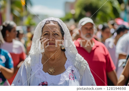 Senior woman wearing white lace headdress and floral dress at outdoor celebration Senior woman wearing white lace headdress and floral dress at outdoor celebration 128194698