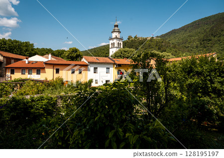 Charming Townscape Of Vipava With Castle View: Colorful Historic Houses And Church Tower Nestled Below Forested Hills With Distant Castle Ruins Under A Clear Blue Sky In Western Slovenia Charming Townscape Of Vipava With Castle View: Colorful Historic Houses And Church Tower Nestled Below Forested Hills With Distant Castle Ruins Under A Clear Blue Sky In Western Slovenia 128195197
