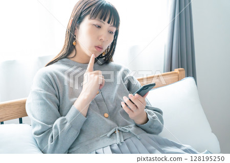A pregnant woman checking a list for preparing for birth in her bedroom A pregnant woman checking a list for preparing for birth in her bedroom 128195250