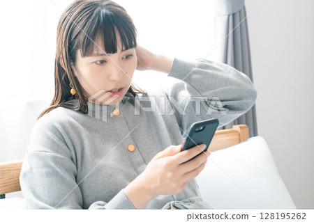 一名孕婦在臥室查看分娩準備清單 一名孕婦在臥室查看分娩準備清單 128195262