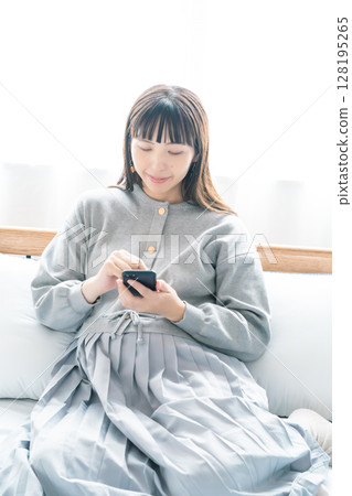 A pregnant woman checking a list for preparing for birth in her bedroom 128195265